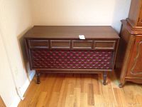 Front view of large wooden vintage Morse console with reddish patterned grille and turned legs.