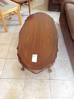 Top view of the wooden oval coffee table showing carved edge details and overall shape.