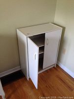 Front view of small white cabinet with both doors open showing adjustable shelving inside.