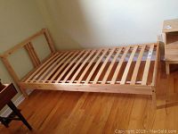 IKEA LURÖY single bed frame assembled against wall, showing wooden slatted base and headboard without mattress