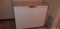 Closed white Admiral chest freezer seen from front in a basement or garage space.