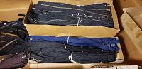 Boxes with bundled black and navy blue metallic zippers in varying lengths
