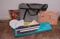 Full contents of the lot showing the tote bag in the back, plastic and wooden palettes, sketchbook, and boxed mat cutter on carpeted floor.
