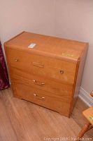 Photo of the full dresser from an angle showing the front and side, highlighting the curved edges and drawer pulls.