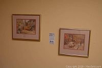 Two smaller Toronto street scene prints by Arto Guzbasiyean framed and hanging on wall