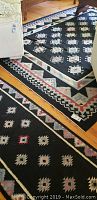 Photo showing corner of Kilim area rug alongside matching runner on wooden floor with furniture around