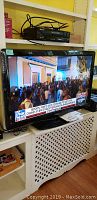 Philips 40 inch flatscreen TV powered on showing a news broadcast with crowd scene on screen.