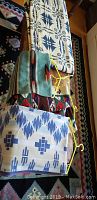 Photo showing two folded vintage blue and white blankets on a patterned rug with Native American motifs.