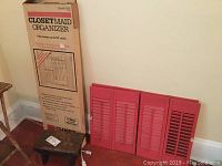Closetmaid Organizer box and four red shutter panels, small stool visible.
