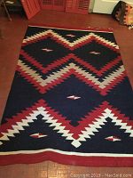 Full view of red, black, white, and beige Native art rug with geometric pattern