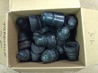 Top view of cardboard box containing about 25 glass insulators in varying dark turquoise shades and shapes, labeled 'turquoise' and '4.5"' on side.