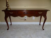 Front view of hall table showing three drawers and Queen Anne style cabriole legs