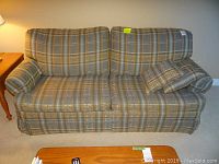 Front view of the two-seat sofa showing the plaid upholstery and cushion arrangement.