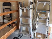 Folded ladder in storage area showing hinges and steps