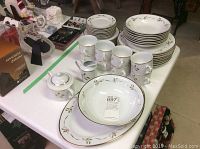 Full view of the Christmas dinnerware set showing plates, bowls, mugs, creamer and sugar bowl arranged on table