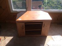Full front view of wooden TV cabinet showing two side cabinets with doors and central open shelving.