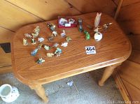 Top view of small oak table with Wade figurines and other decorative items arranged on top.