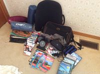 Photo showing entire lot laid out on carpet including travel bags, photo albums, books, clocks, and other travel accessories.