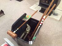 View of mallets, balls, wickets and tote container on carpeted floor