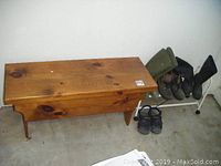 Solid pine bench with visible knots and grain, showing minor wear.