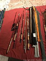 Overview of multiple fishing rods and rod sleeves laid out on fabric surface
