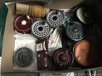 Box containing multiple metal perforated reels, leather case, yellow backing line, sealed spare spool and packaging