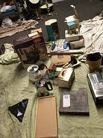 Full view of lot items including coffee maker box, various boxed kitchen utensils, knives, vegetable chopper, and casserole dishes.