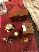 Collection of vintage clocks, bell, compass, and telescope on fabric surface