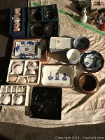 Overview of all tea sets, plates, bowls, and trays displayed on cloth surface
