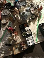 Wide view of assortment of Asian decor items including vases, plates, figurines, and the boxed sake set