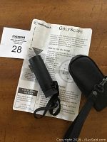 RadioShack GolfScope handheld scope with black case and instruction sheet on wood surface