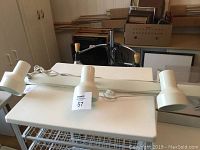 White metal 3-light track fixture, showing overall length and adjustable heads.