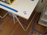Photo showing white IKEA table top with laminate peeling off the corner and visible marks on surface
