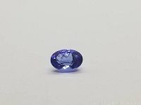 Clear top-down view of the oval Tanzanite gemstone showing blue and purple coloration and faceting.