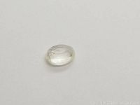 Oval white sapphire gemstone displayed on plain white background showing transparency and clarity.