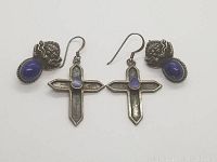 Two pairs of vintage sterling silver earrings: one pair cross-shaped with oval dark blue Lapis Lazuli stones, the other pair dragon face with similar oval Lapis Lazuli stones. Both pairs have hook ear wires and vintage patina.