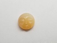 Top-down view of the carved moonstone showing the detailed facial features and coloration.