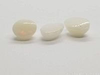 Front perspective of three white fire flash opals showing translucent body and fire flash colors
