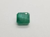 Front-facing view of rectangular step-cut emerald on white background