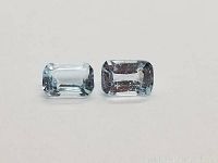 Close-up of two emerald cut sky blue topaz gemstones side by side on white background showing clean clarity and color.