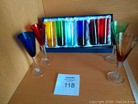 Front view of six colored shot glasses in box and four stemmed liqueur glasses.