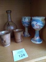 View of the lot items showing pottery decanter, two matching small pottery cups, and two Bailey Brown goblets with colorful glaze.