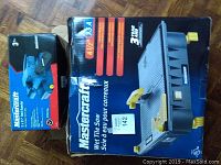 Photo showing Mastercraft 3 x 21 inch belt sander box with blue tool and label visible, next to Mastercraft 4.5 inch 3.5 amp wet tile saw box featuring photo and specs.