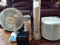 Full lot showing all items: Supra oscillating fan, Holmes InstaFurnace heater, two Environizer air cleaners, and Bionaire air purifier.