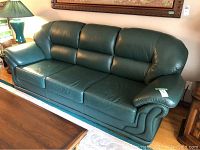 Front-right three-quarter view of green leather couch