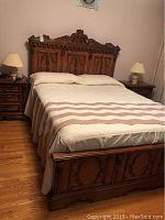 View of the whole bed including headboard, footboard, bedding and surrounding floor area.