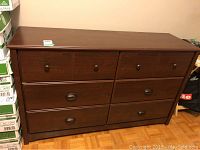 Front view of the wood composite dresser showing the six drawers and two types of drawer pulls.