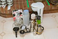 Group photo showing all coffee-related items on the floor including the drip coffee maker, silver Italian espresso pots, thermoses, glass pot and boxed candle holder.