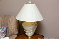 Full view of the table lamp showing the base and shade next to a couch.