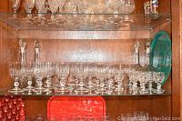 Wide view of crystal stemware and decanters on shelf with green tray visible